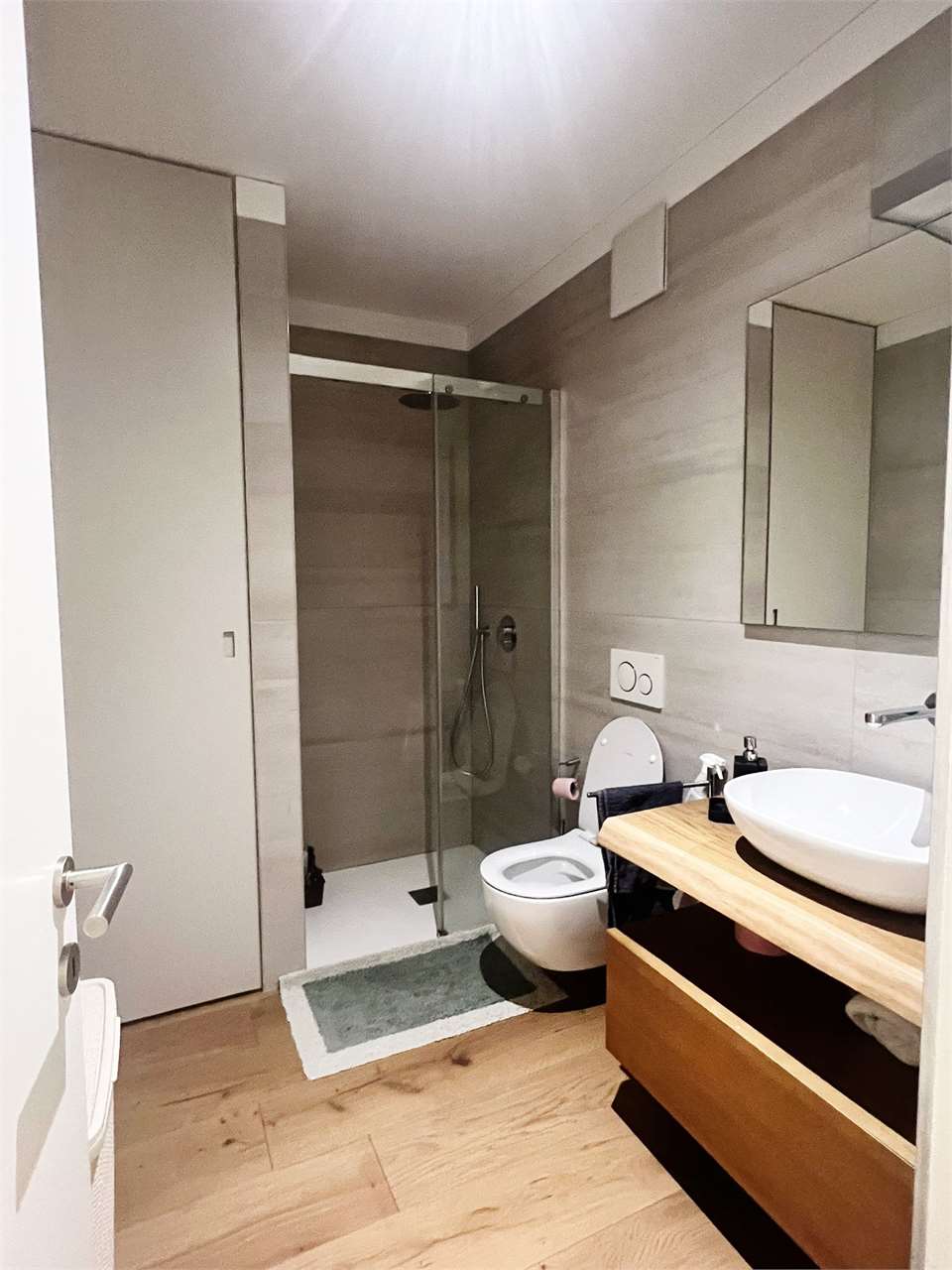 Modernes Bad mit Dusche und Holzwaschtisch