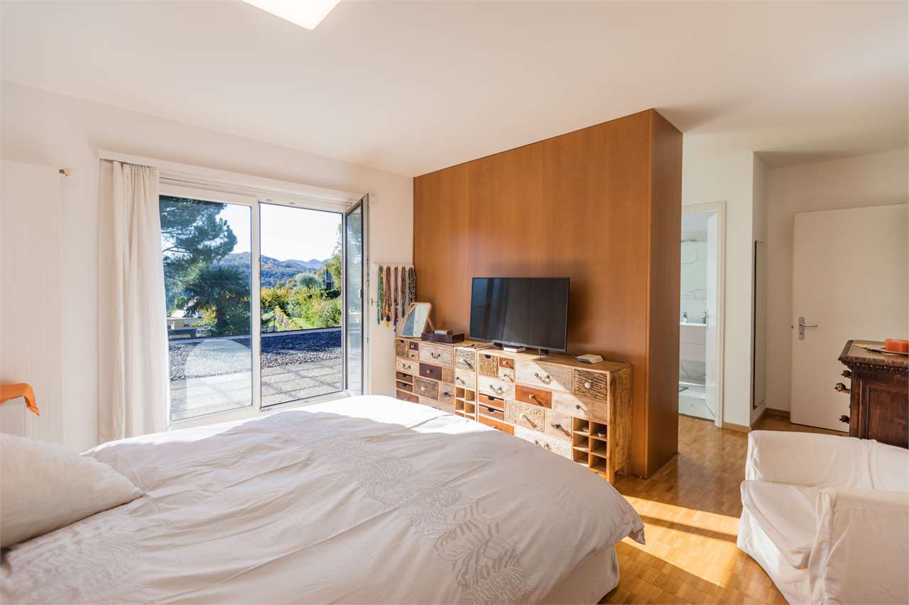 Helles Schlafzimmer mit Balkon- bzw. Terrassentür und Blick ins Grüne