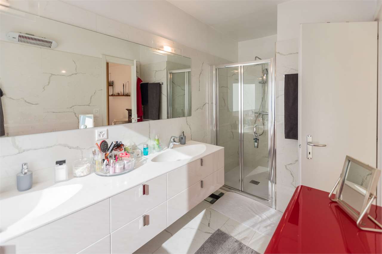 Modernes Badezimmer mit Doppelwaschtisch und Glasdusche