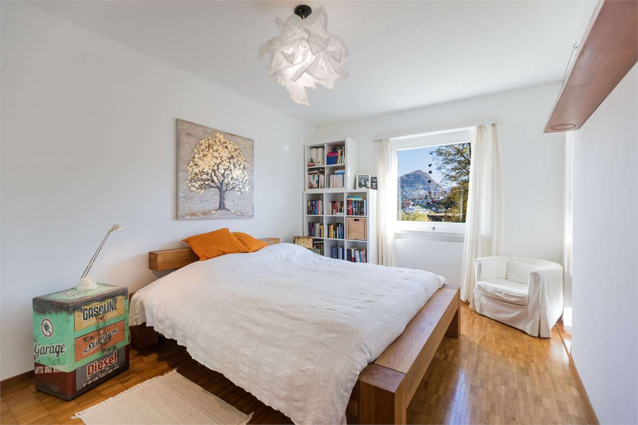 Helles Schlafzimmer mit Holzboden und Bergblick