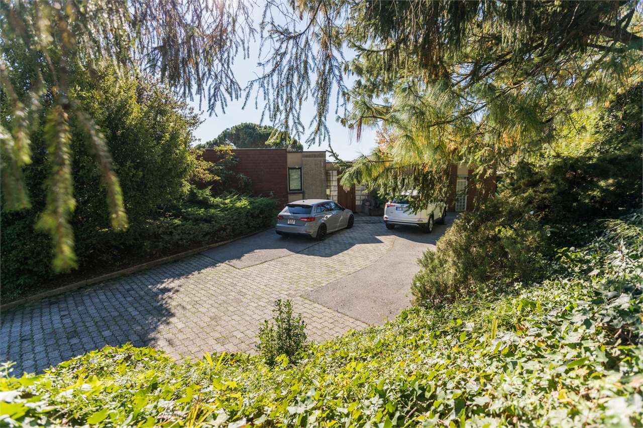 Zufahrt mit zwei geparkten Autos vor moderner Wohnbebauung