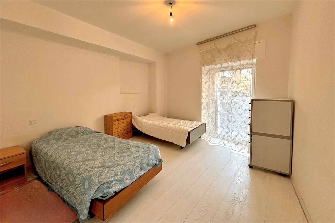 Helles Schlafzimmer mit zwei Betten und Balkonzugang