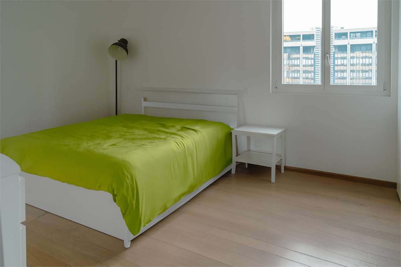 Schlichtes Schlafzimmer mit grünem Bettbezug