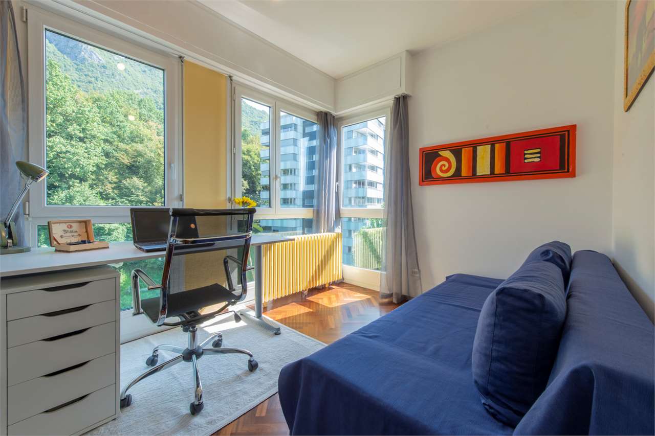 Helles Schlafzimmer mit Arbeitsbereich und großem Bergblick