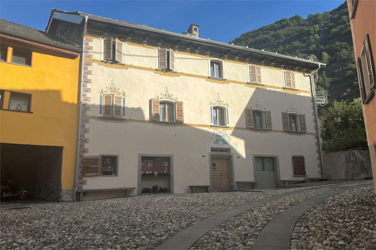 Historische Fassade mit Innenhof und Bergkulisse