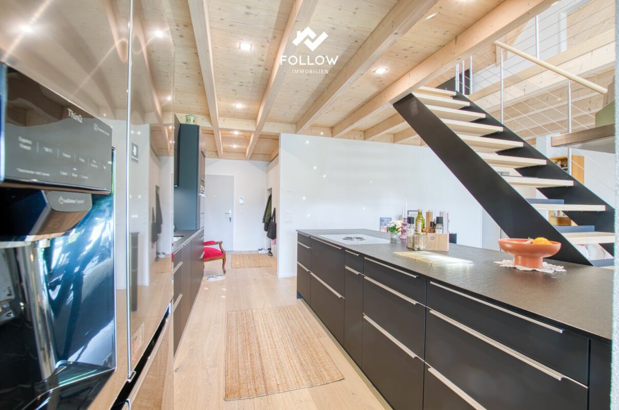 Offene moderne Küche mit Treppe und Holzbalkendecke