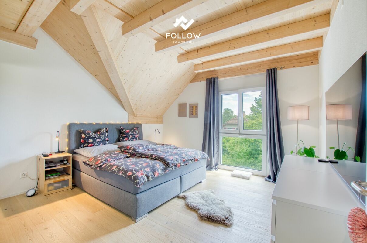 Dachgeschoss-Schlafzimmer mit sichtbaren Holzbalken