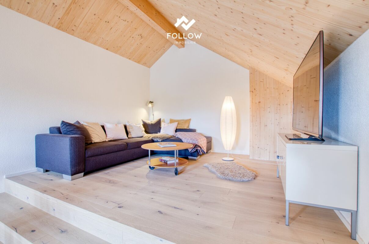 Helles Dachgeschoss-Wohnzimmer mit Sofa und TV