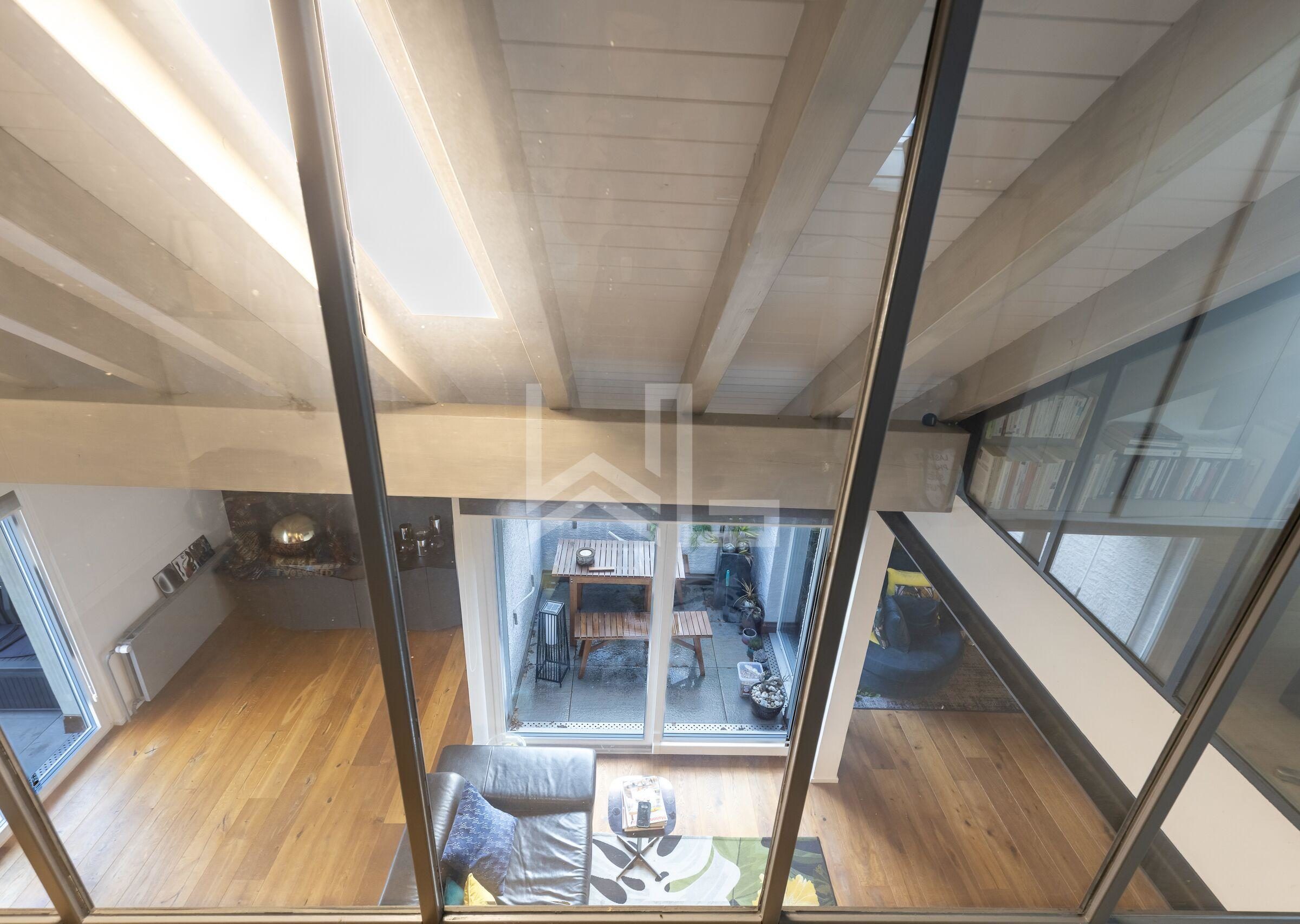 Luftige Galerie mit Blick in den Wohnraum und auf den Innenhof