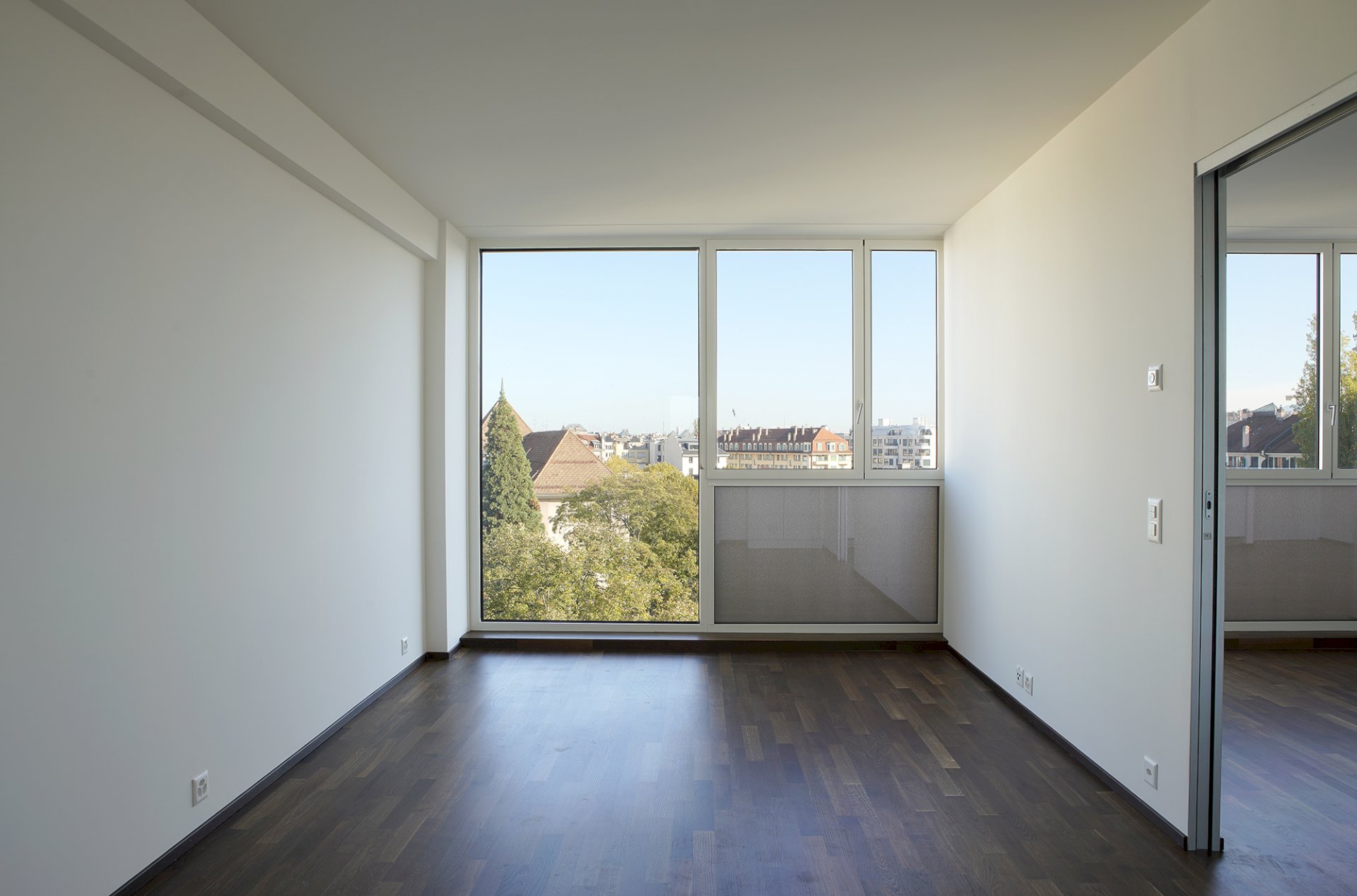 Leerer Wohnraum mit großem Fenster und Ausblick