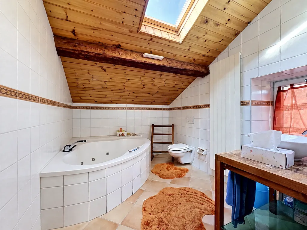 Badezimmer mit Eckwanne und Holzdecke
