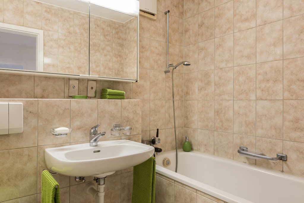 Badezimmer mit Wanne und Waschtisch