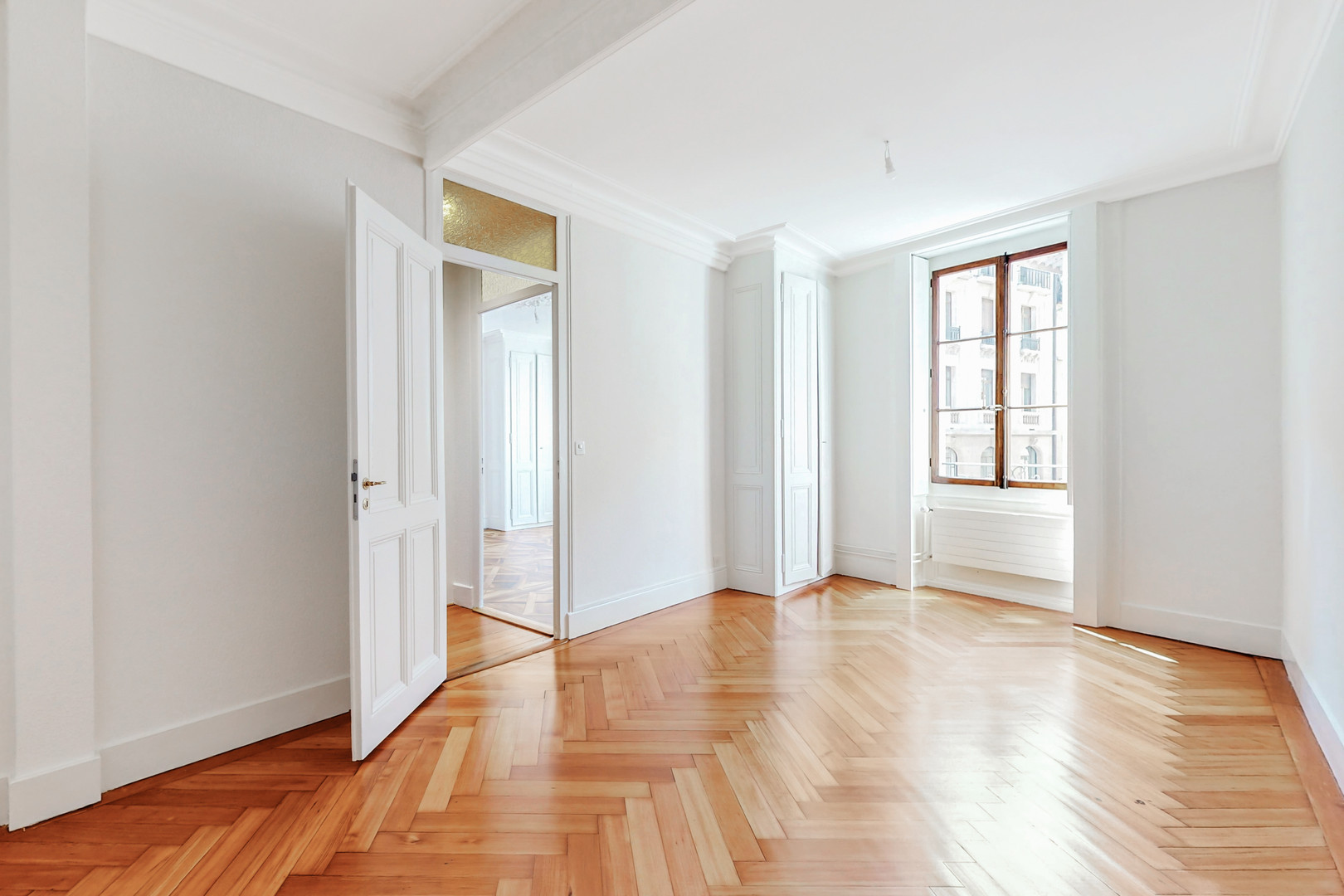 Heller leerer Altbau-Raum mit Fischgrätparkett
