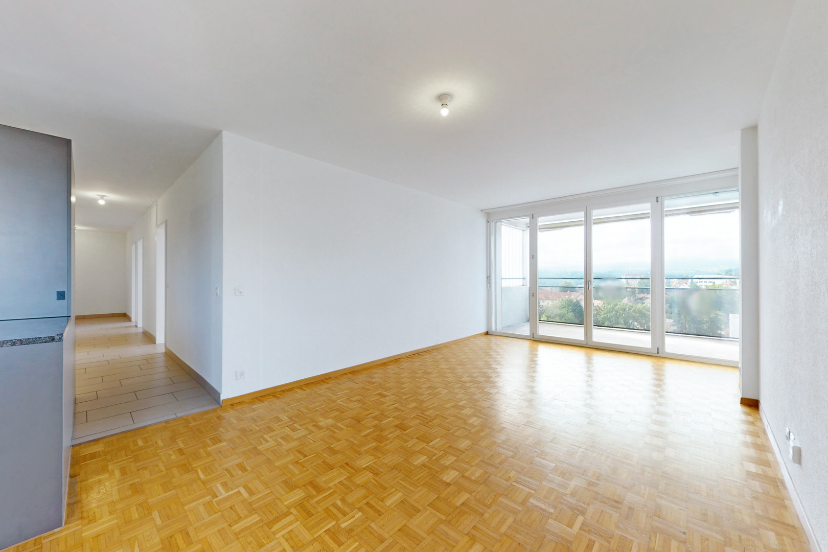 Heller Wohnraum mit Balkon und Parkettboden