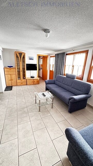 Helles Wohnzimmer mit Sofa und Schrankwand