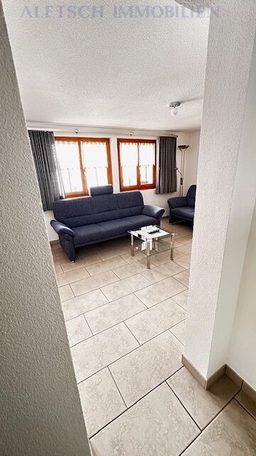 Wohnzimmer mit Sofa und Fliesenboden
