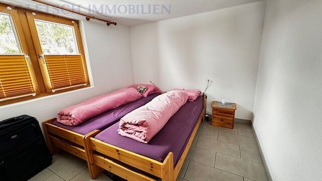 Schlafzimmer mit Doppelbett und Holzfenster
