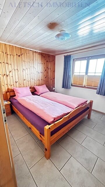 Gemütliches Schlafzimmer mit Holzvertäfelung