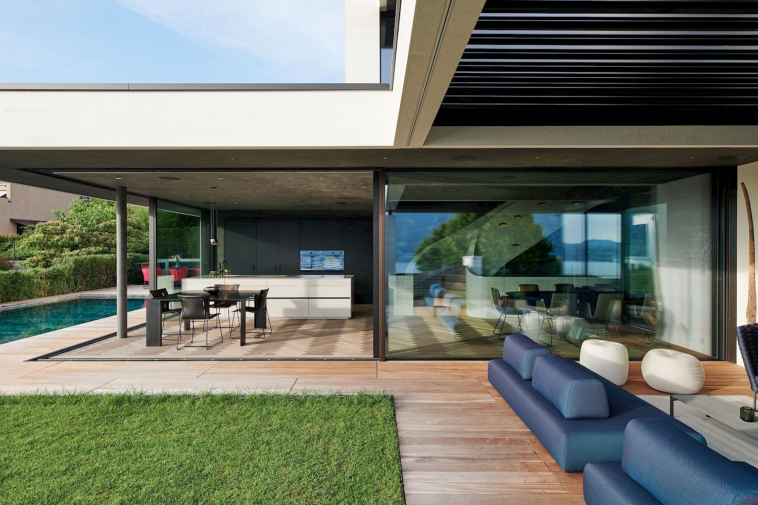 Moderne Terrasse mit Pool und offener Wohnküche