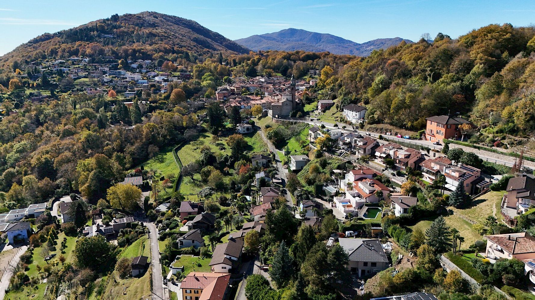 Luftaufnahme einer grünen Tallandschaft mit Wohnsiedlung
