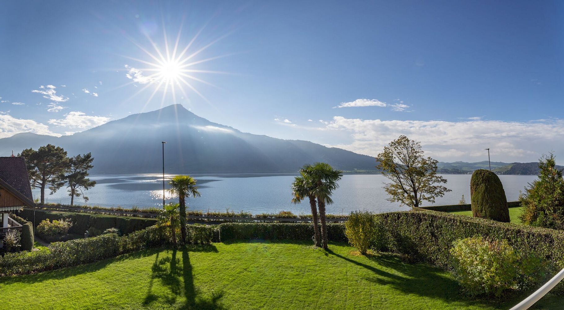 Seeblick mit Bergpanorama und gepflegtem Garten