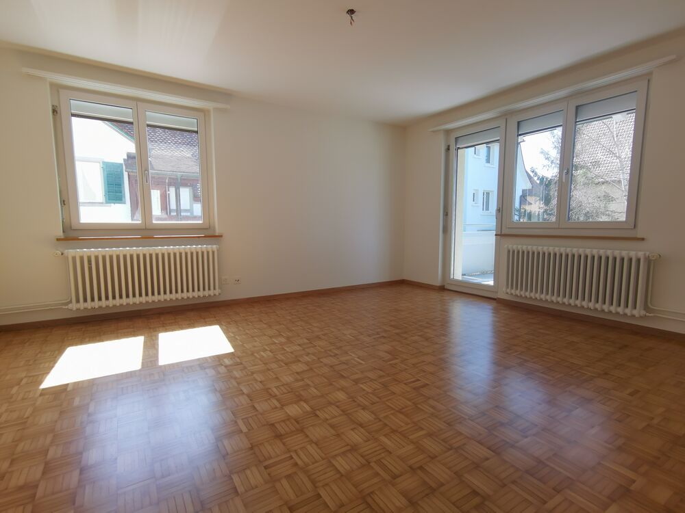 Leeres Wohnzimmer mit Parkett und Fenstern