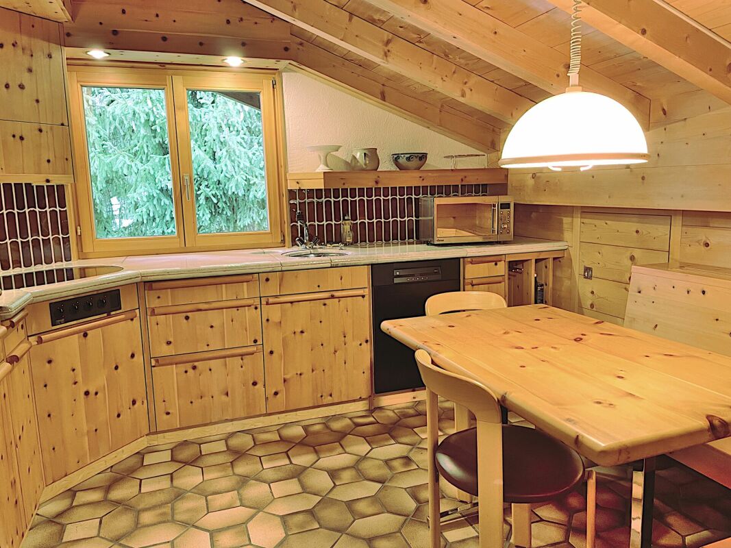 Gemütliche Holzküche mit Spitzdach und Esstisch