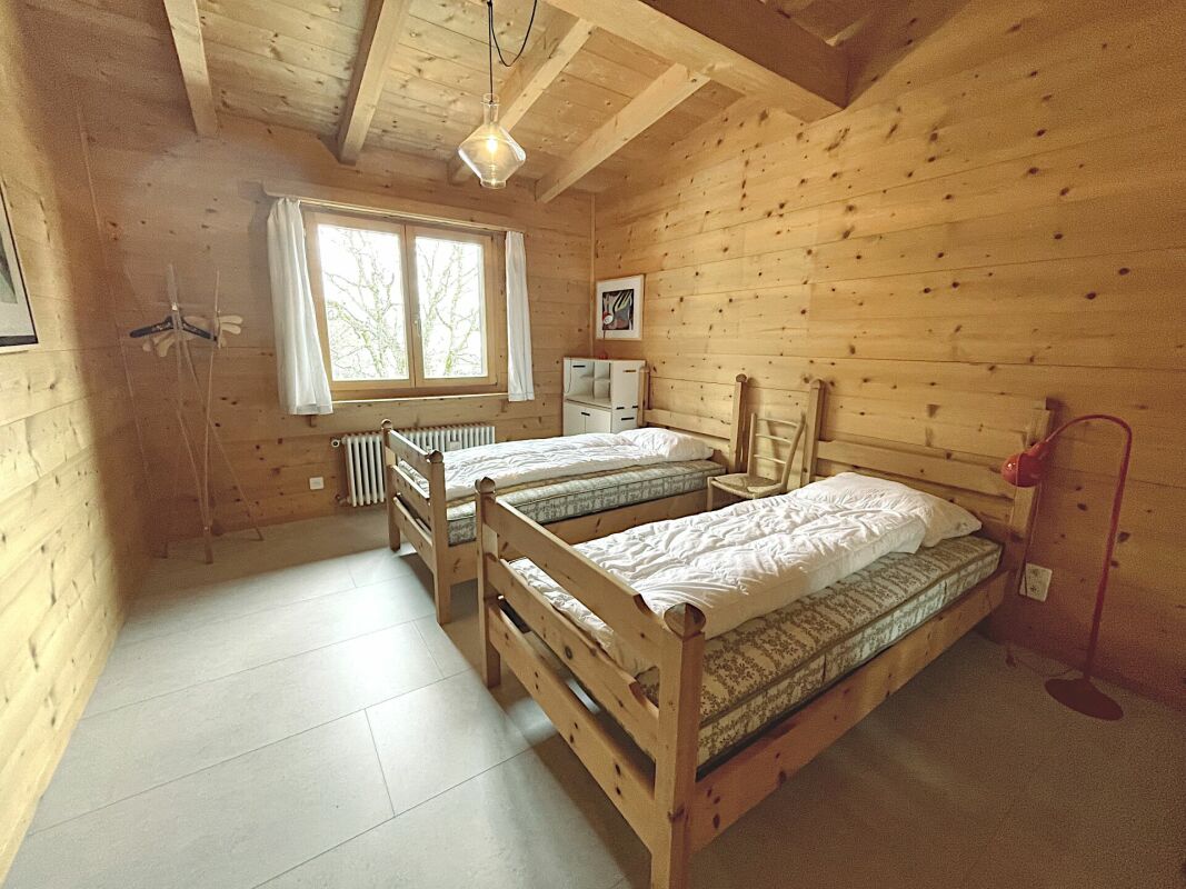 Holzverkleidetes Schlafzimmer mit zwei Einzelbetten