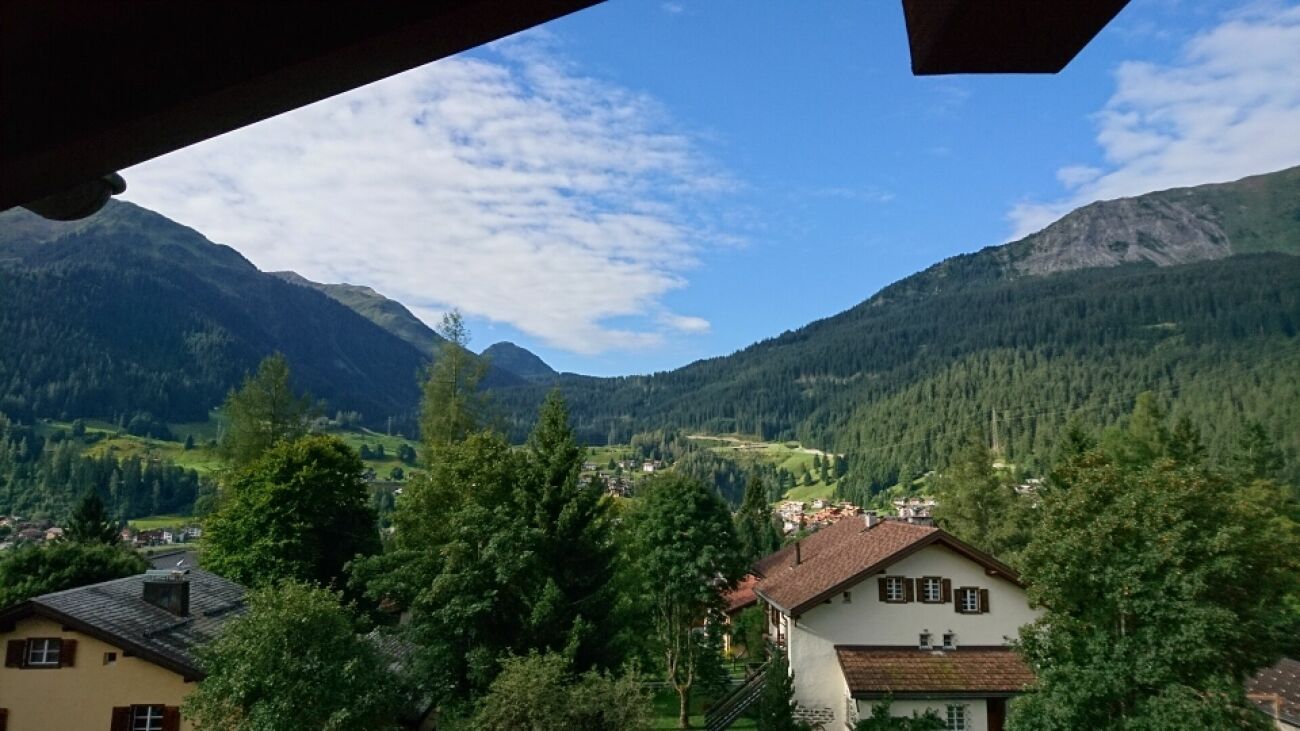 Bergblick über ein alpines Tal mit Wohnhäusern