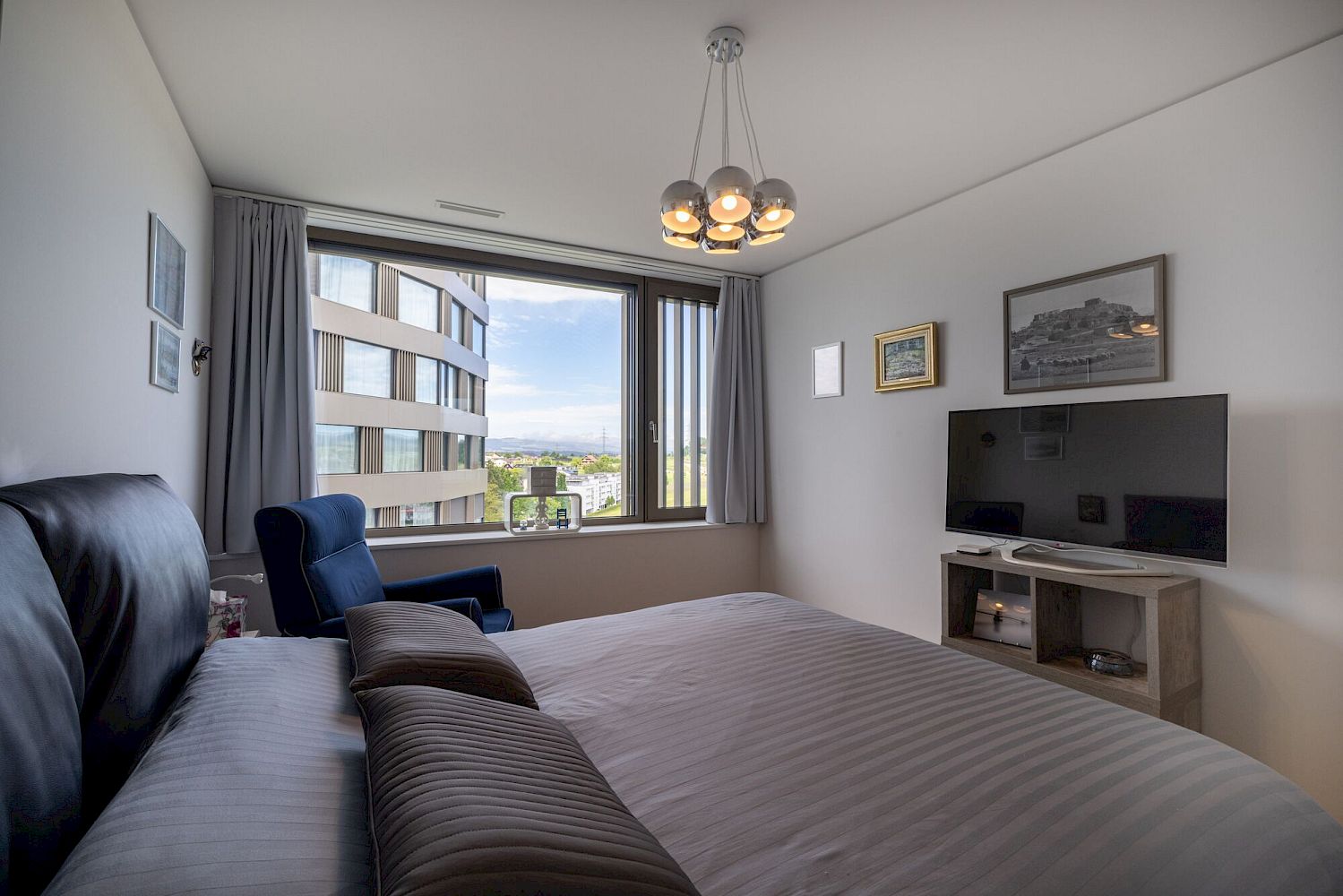 Schlafzimmer mit großem Fenster und TV