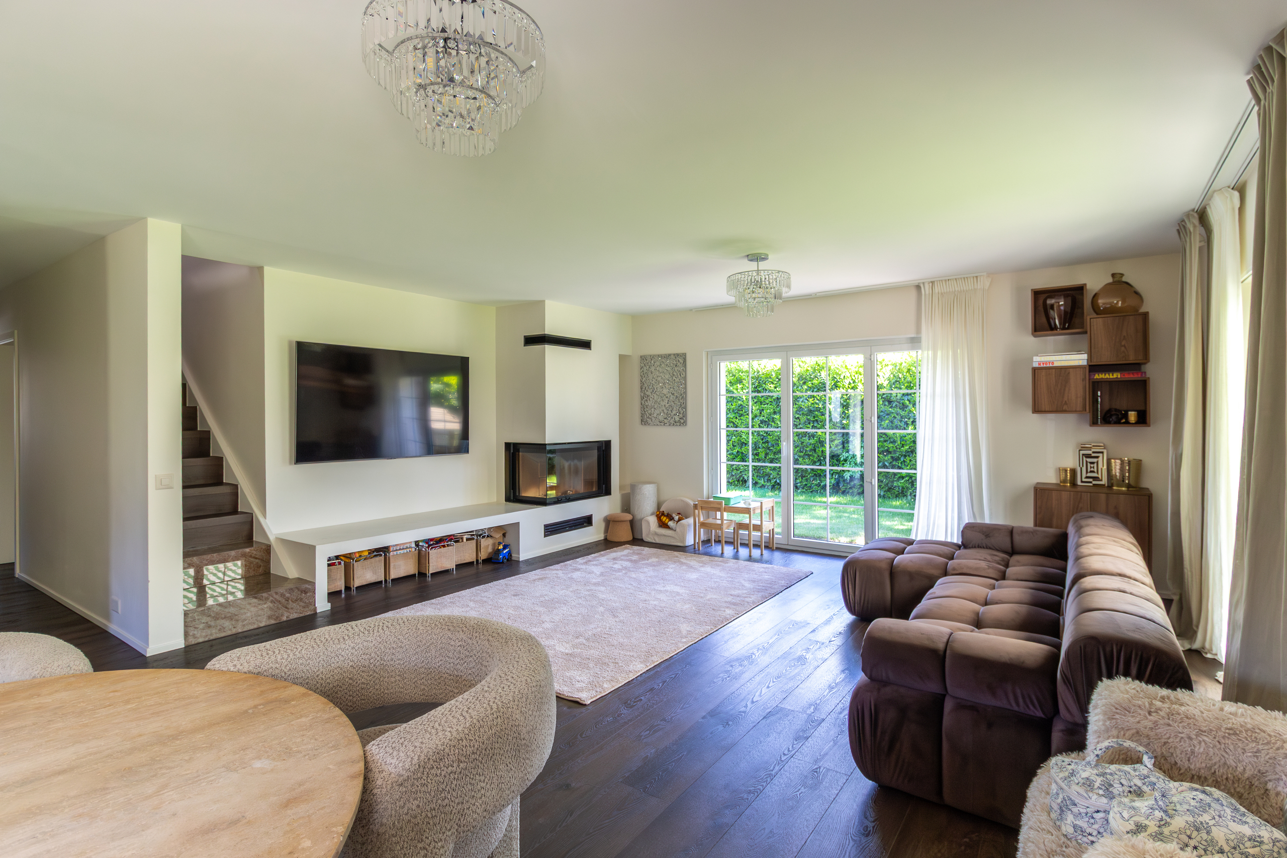 Modernes Wohnzimmer mit Kamin und Gartenblick