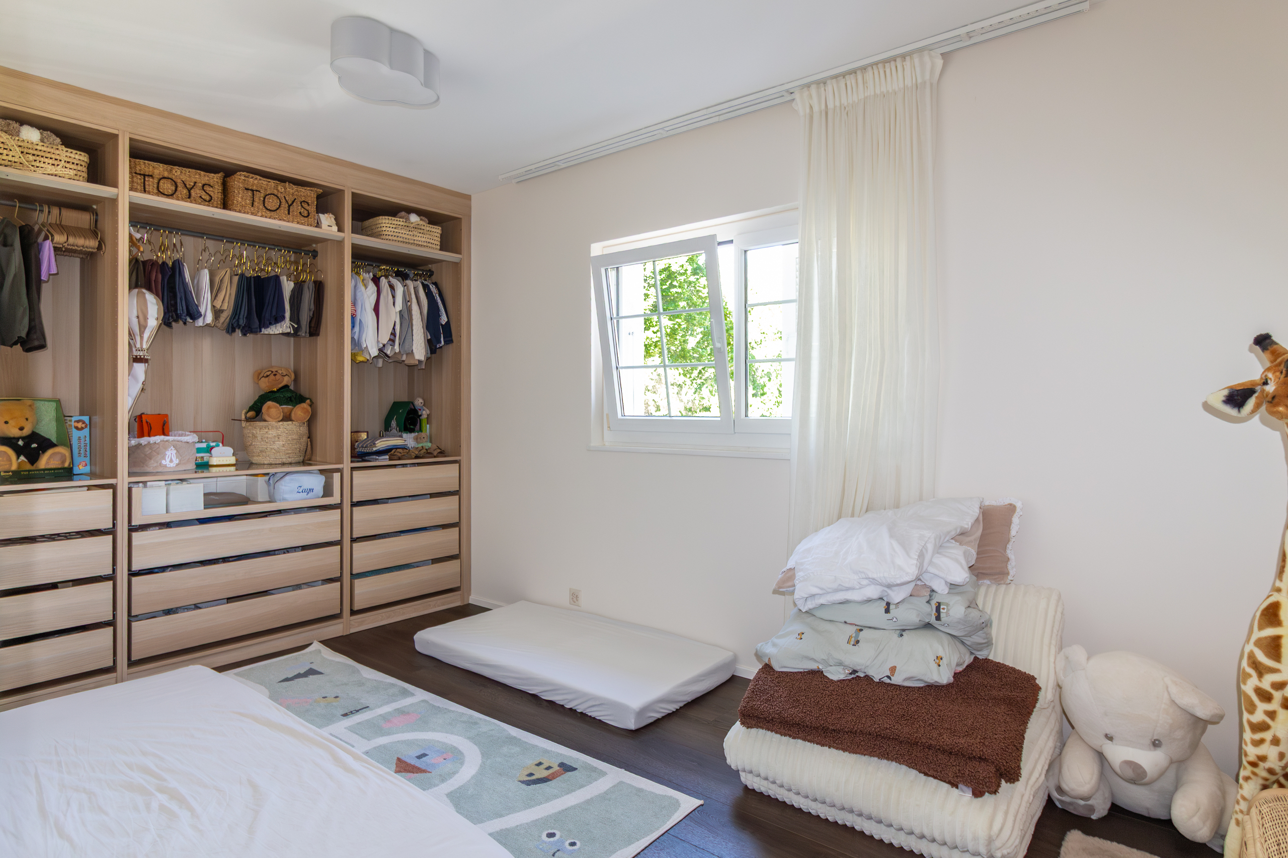 Kinderzimmer mit offenem Kleiderschrank und Tageslicht