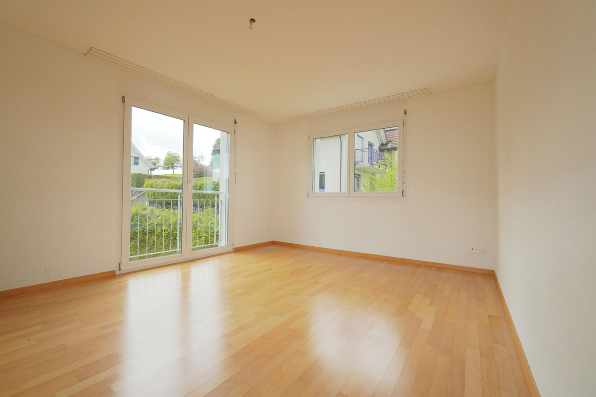 Leerer heller Wohnraum mit Balkon- und Fensterblick