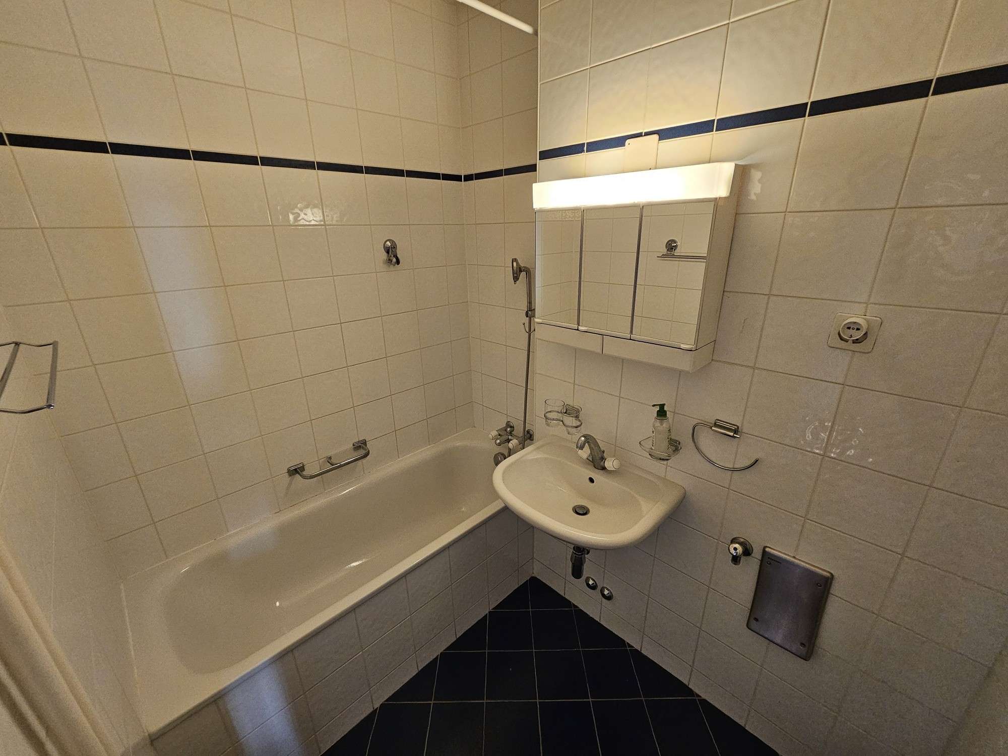 Kleines Badezimmer mit Badewanne und Wandspiegelschrank