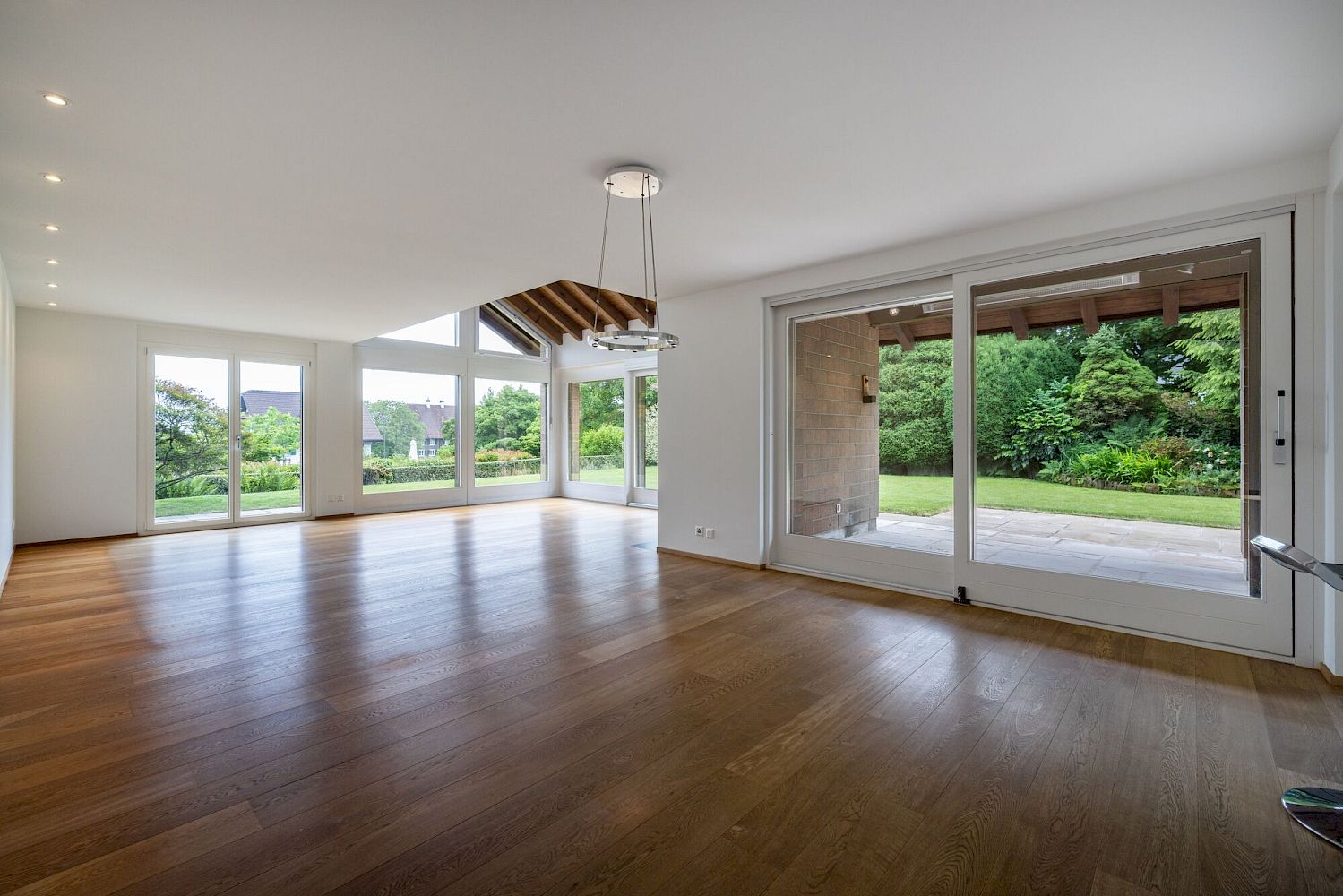 Großer, leerer Wohnraum mit Blick in den Garten