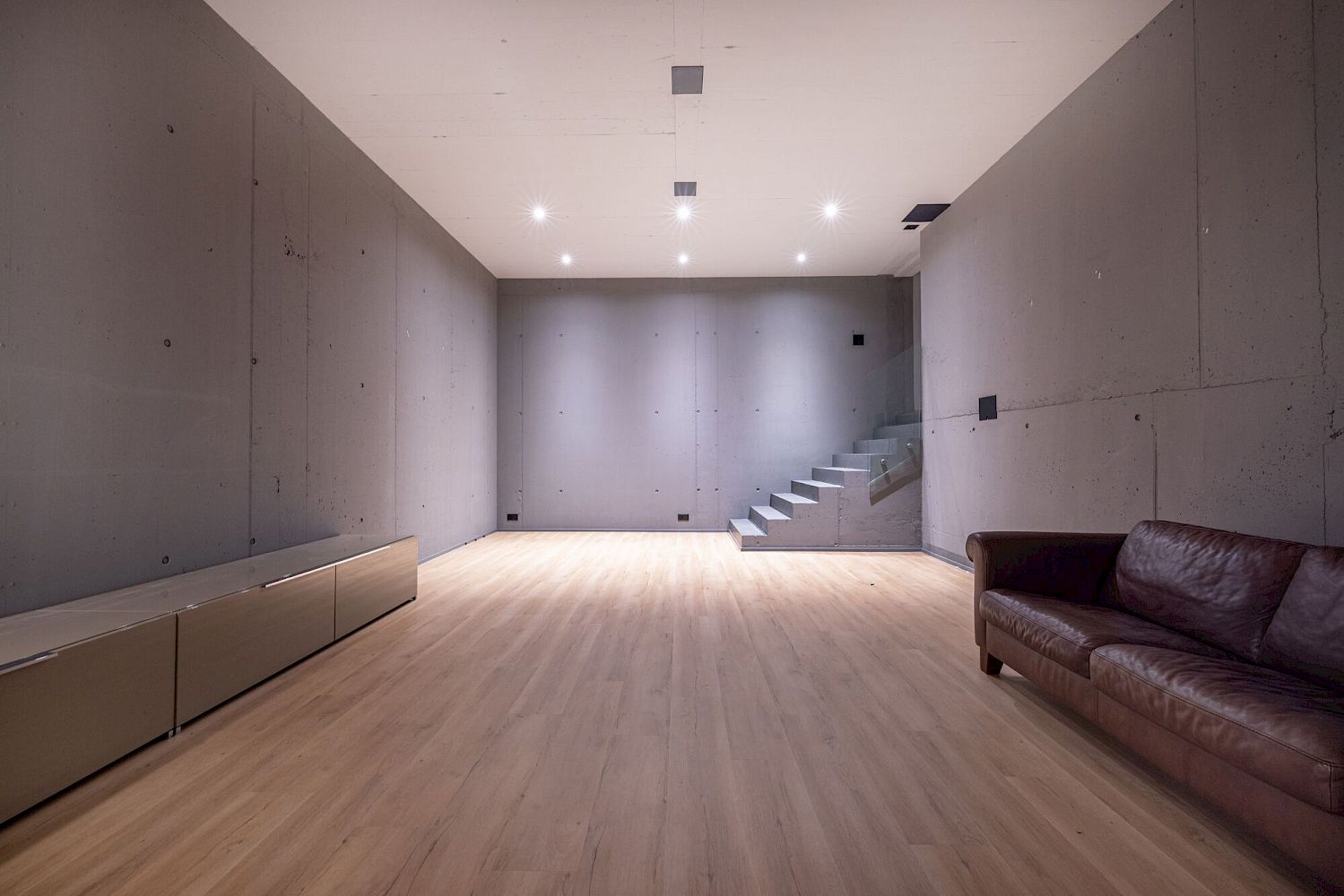 Moderner Wohnraum im Rohbau-Stil mit Treppe