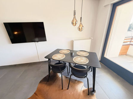 Moderner Essbereich mit TV und Balkonzugang