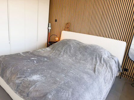 Modernes Schlafzimmer mit Bett und Holzlamellenwand
