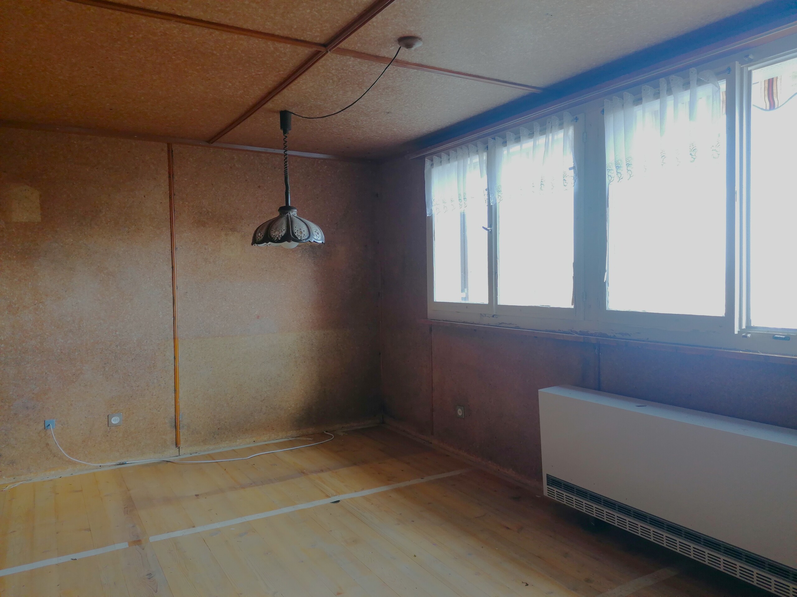 Leerer Raum mit Holzdecke und großem Fenster