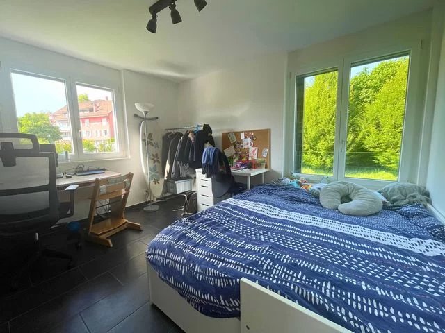 Helles Schlafzimmer mit Arbeitsplatz und Blick ins Grüne