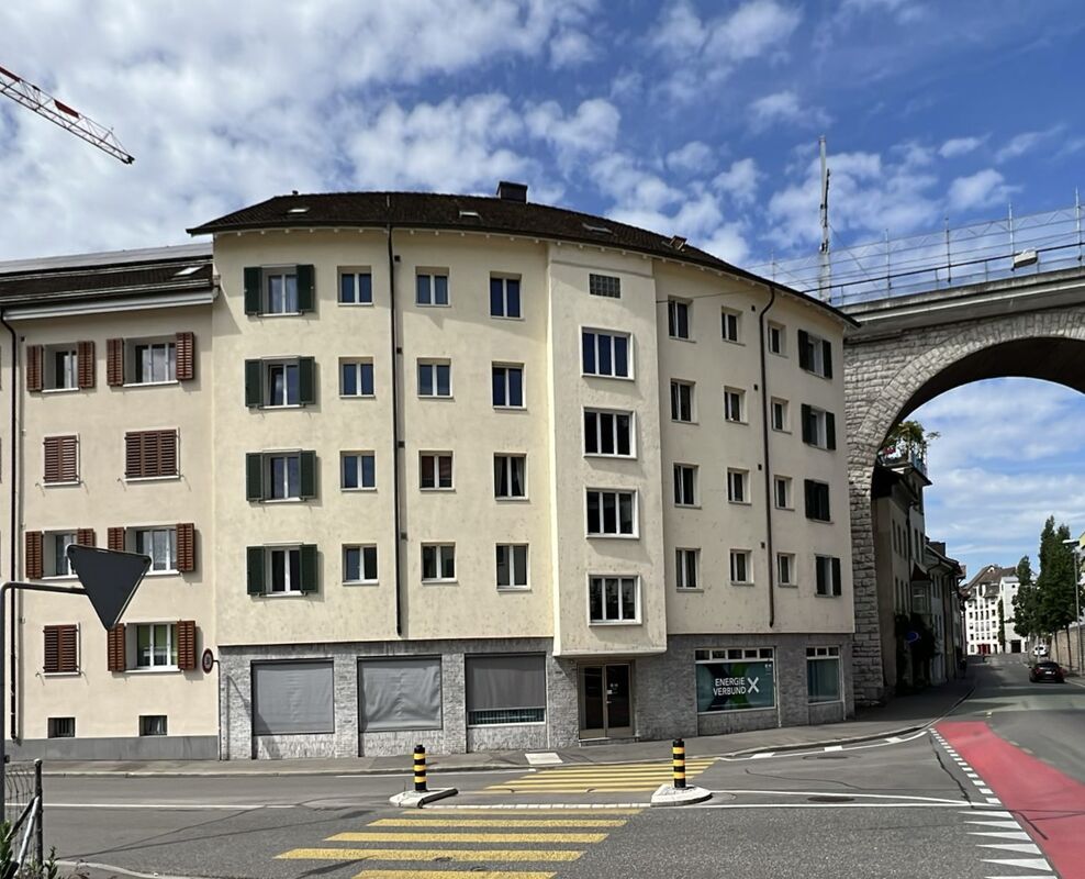 Mehrfamilienhaus an Straßenecke mit Viadukt