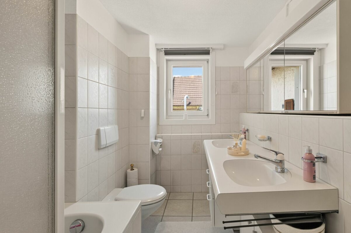 Helles Badezimmer mit Doppelwaschtisch und WC