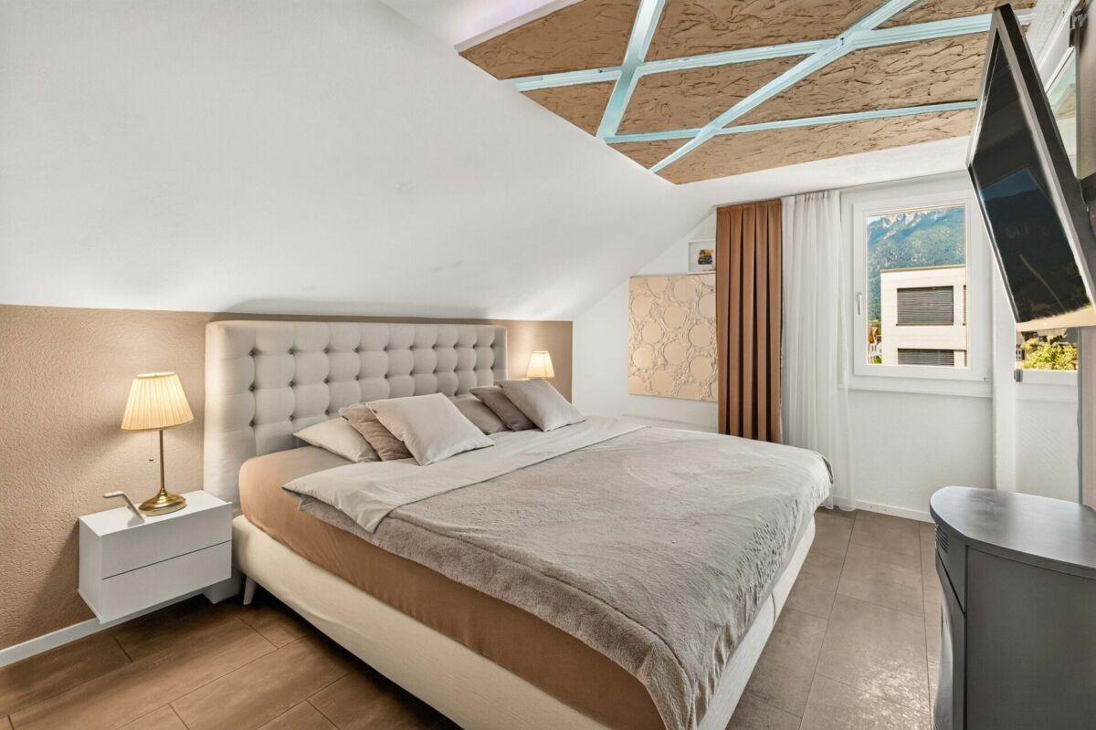 Schlafzimmer im Dachgeschoss mit großem Bett und Fensterblick