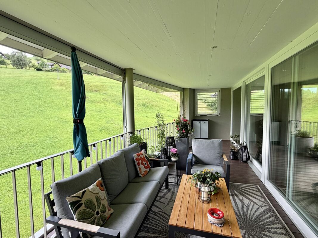 Überdachter Balkon mit Sitzgruppe