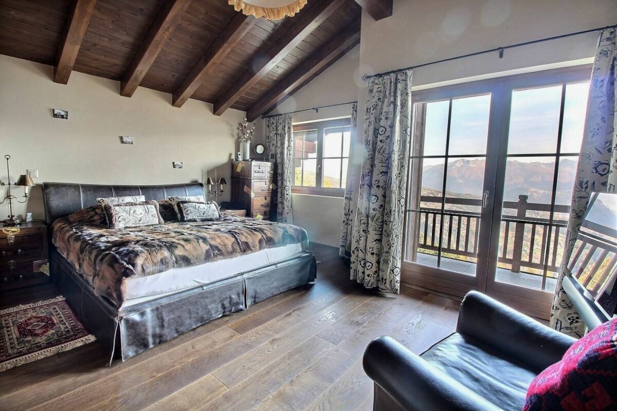 Schlafzimmer mit Bergblick und sichtbaren Holzbalken
