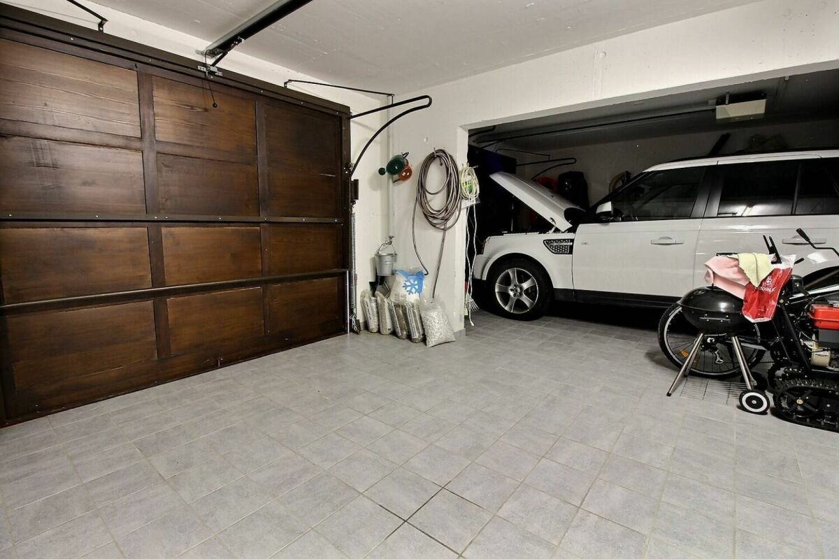 Garage mit offenem Tor und parkendem SUV