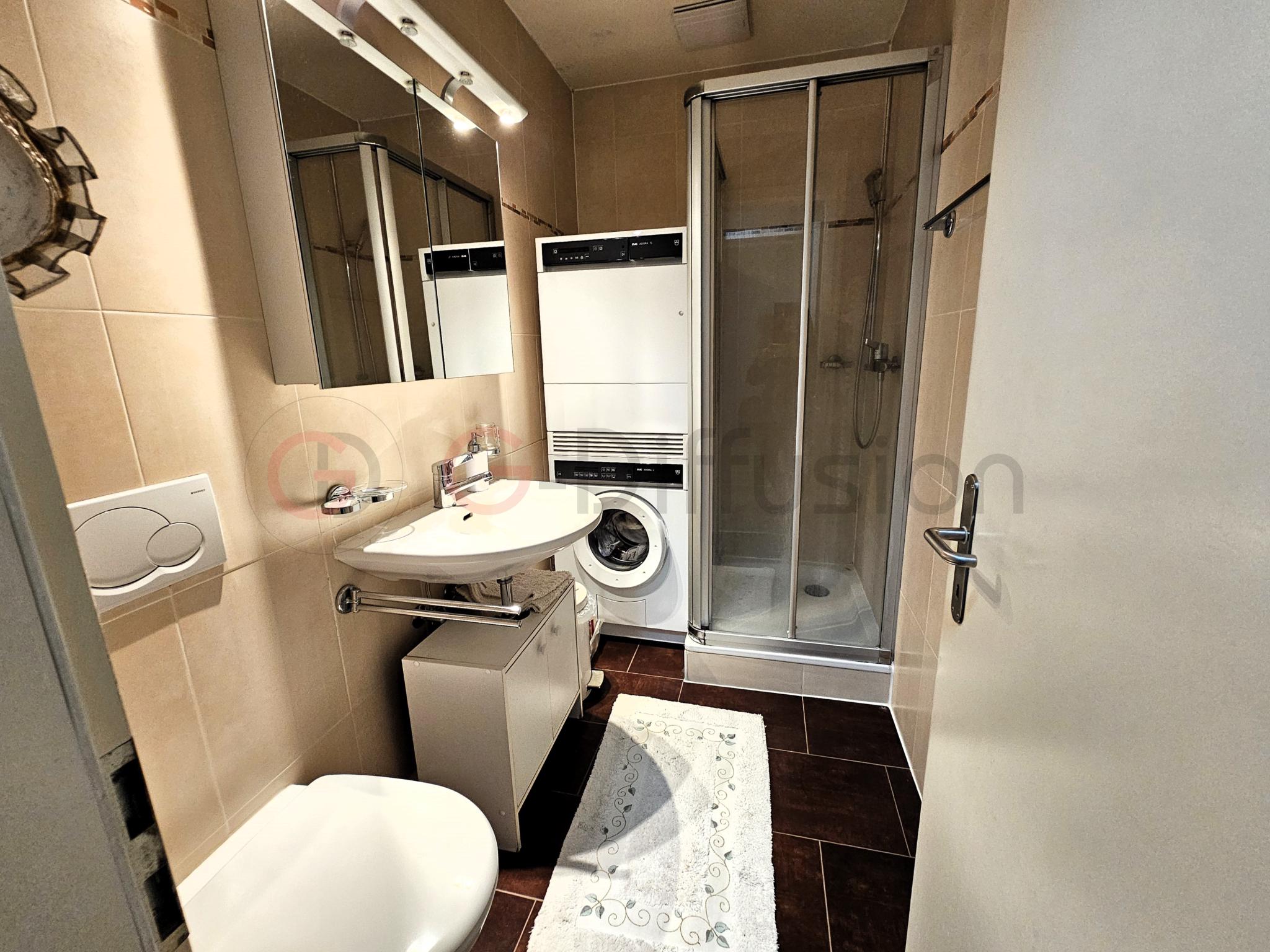 Kleines Badezimmer mit Dusche und Waschmaschine