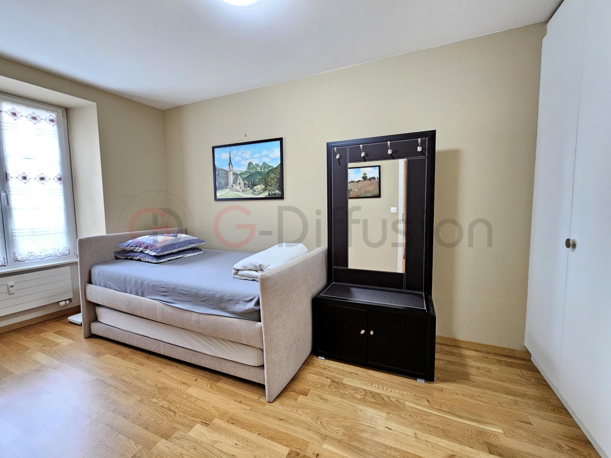 Helles Schlafzimmer mit Einzelbett und Spiegelkommode