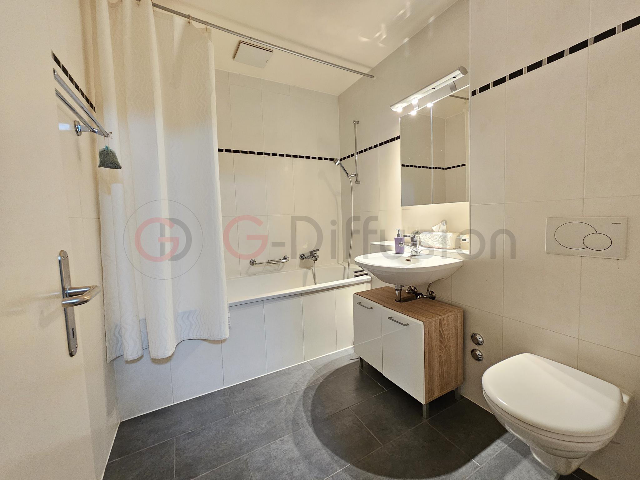Modernes Badezimmer mit Badewanne, Waschtisch und WC