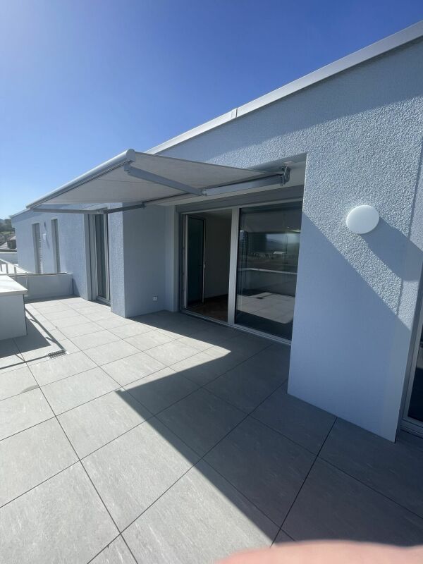 Dachterrasse mit moderner Fassade und Markise